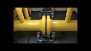 Hydraulic Zero Gap flange spreader mounted between two yellow industrial pipe flanges. The tool uses internal bolt hole engagement and a hydraulic cylinder to safely separate tightly sealed flange joints. Ideal for high-pressure maintenance in oil, gas, and chemical applications.